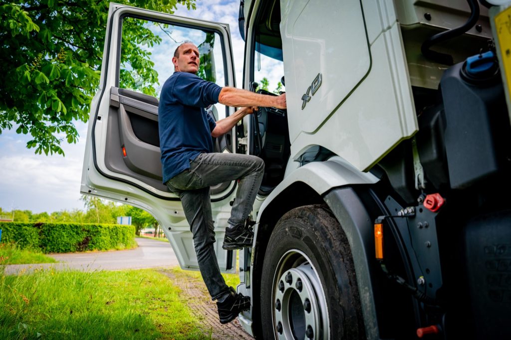Chauffeur stapt in de cabine van een Voets Transport kraanwagen