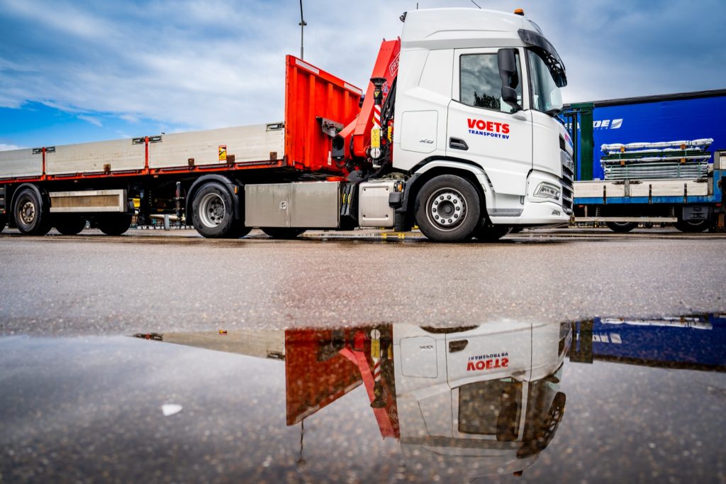 Kraanwagen van Voets Transport met vlakke oplegger