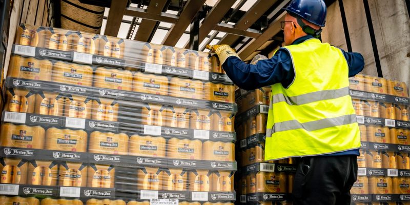 Pallets blikken drank worden geladen in een oplegger van Voets Transport